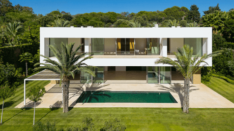 Modern villa for sale featuring a sleek design, private pool, and palm-lined garden at Finca Cortesin