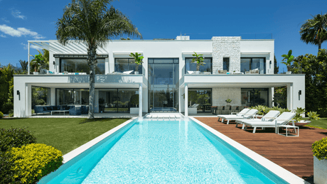 Contemporary luxury villa designed by Carlos Lamas in Marbella, featuring a sleek modern facade, expansive pool, and lush gardens