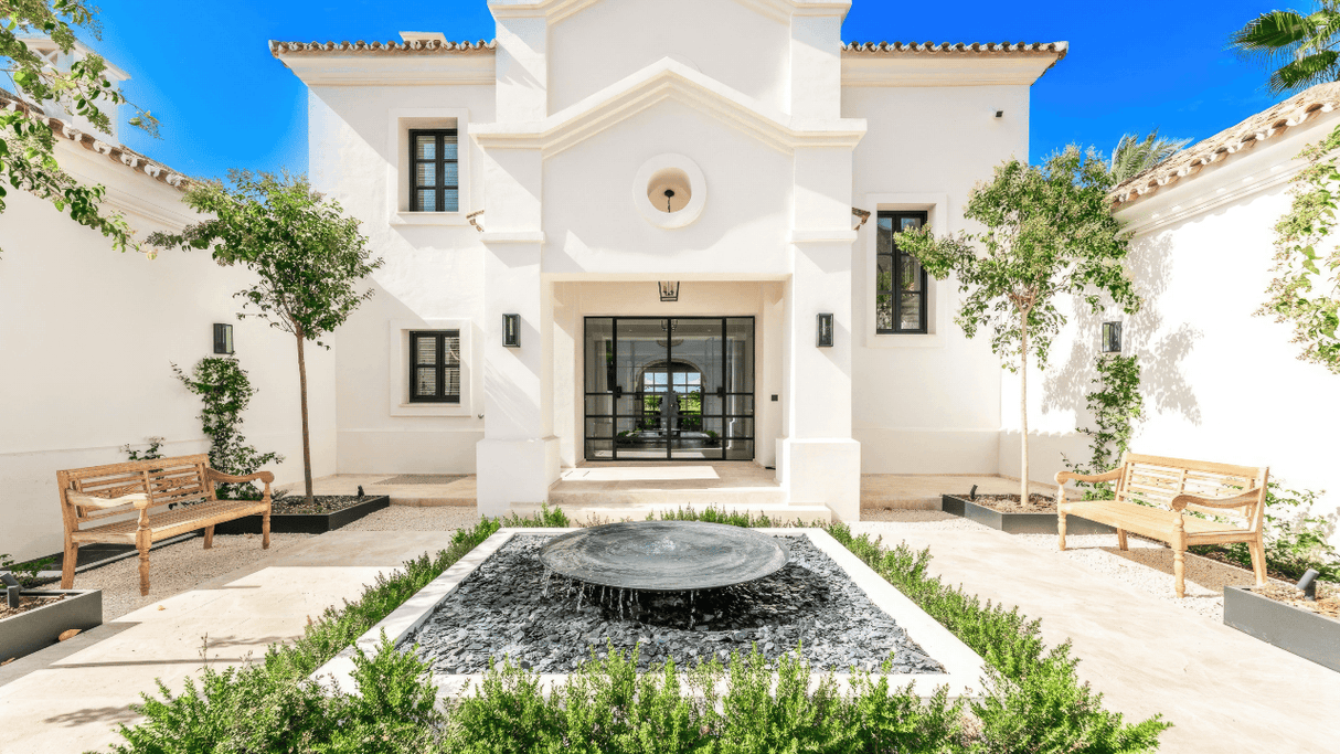 Elegant front facade of a luxurious mansion in Sierra Blanca with a central water feature and lush greenery