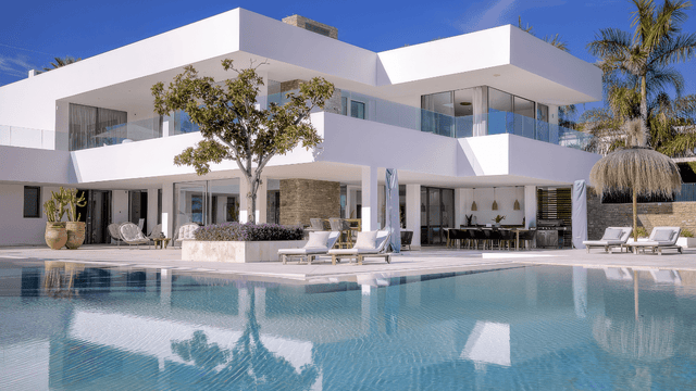 Modern luxury villa with sleek architecture, a spacious pool, and stylish outdoor living spaces in La Cerquilla, Nueva Andalucia