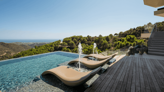 Luxury villa for sale in Monte Mayor with an infinity pool, panoramic sea views, and modern outdoor lounging area surrounded by nature