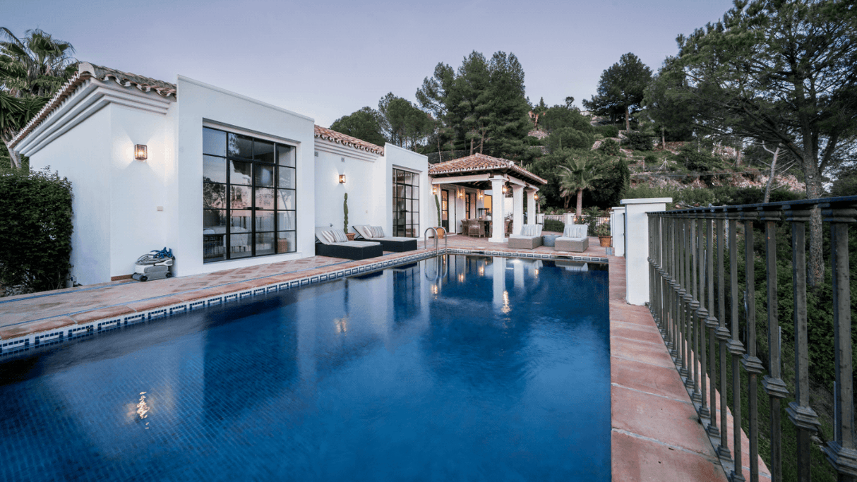 Luxury villa with a private pool and spacious terrace, surrounded by lush greenery in El Madroñal, Benahavis, featuring modern Andalusian architecture and scenic views