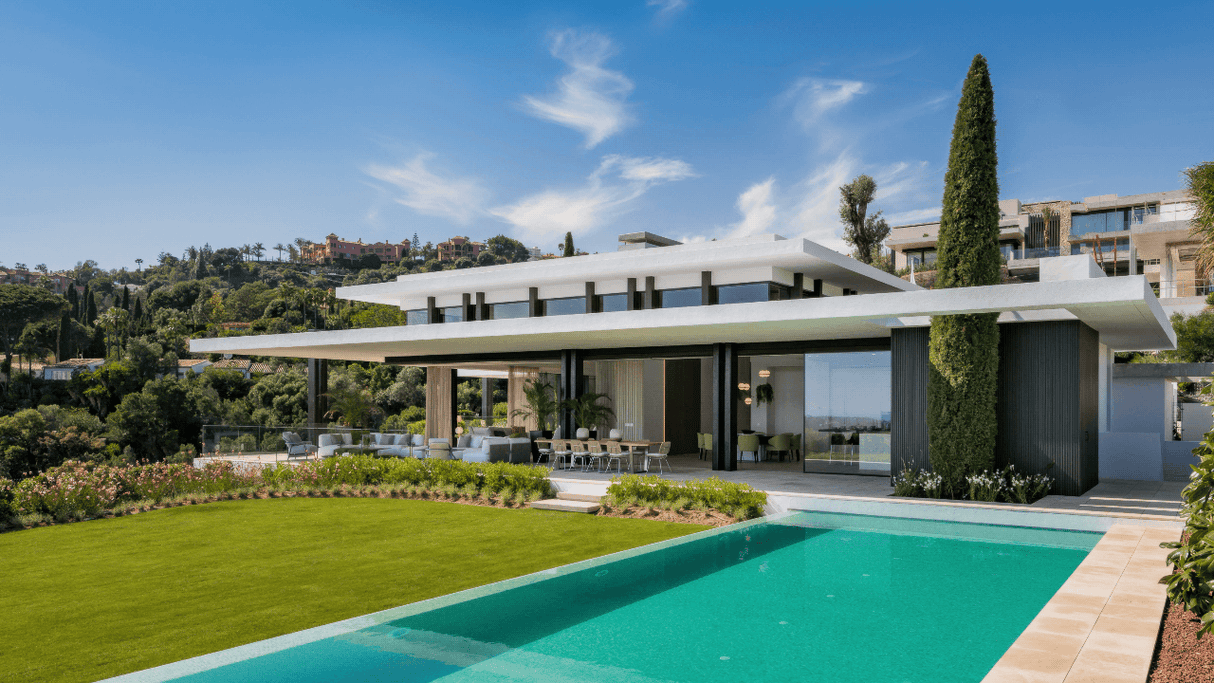 Modern luxury villa with sleek architecture, large pool, and lush landscaped garden in La Quinta, Marbella, surrounded by scenic greenery and panoramic views